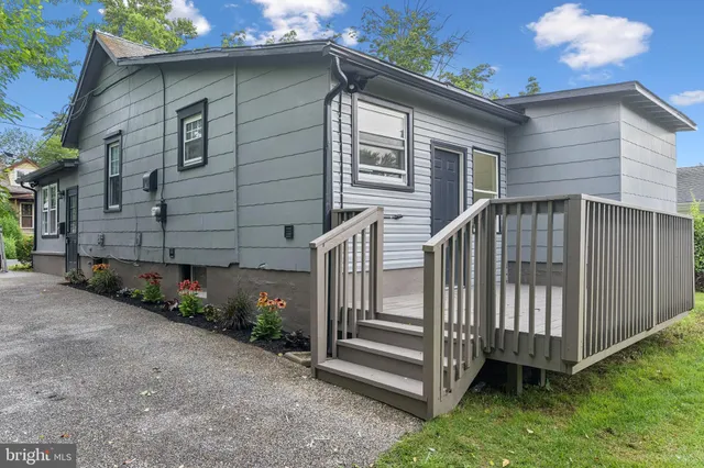 a view of a house with a yard and wooden fence
