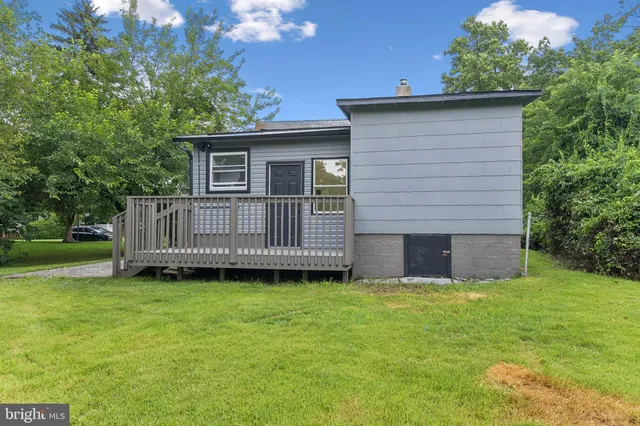 a view of a house with a yard and deck