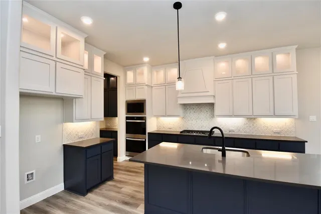 a kitchen with stainless steel appliances granite countertop a sink a stove and a refrigerator
