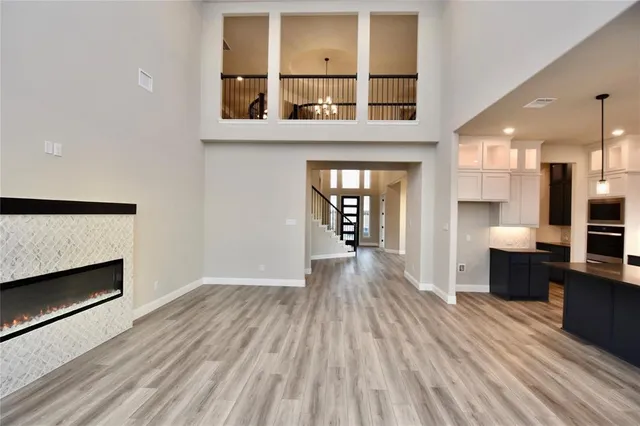 a view of a living room with wooden floor and a fireplace