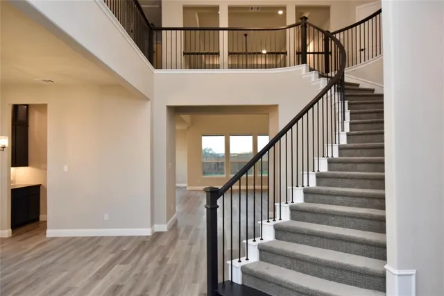 a view of staircase with wooden floor and white walls