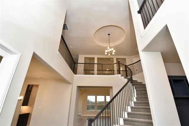 a view of staircase with railing and white walls