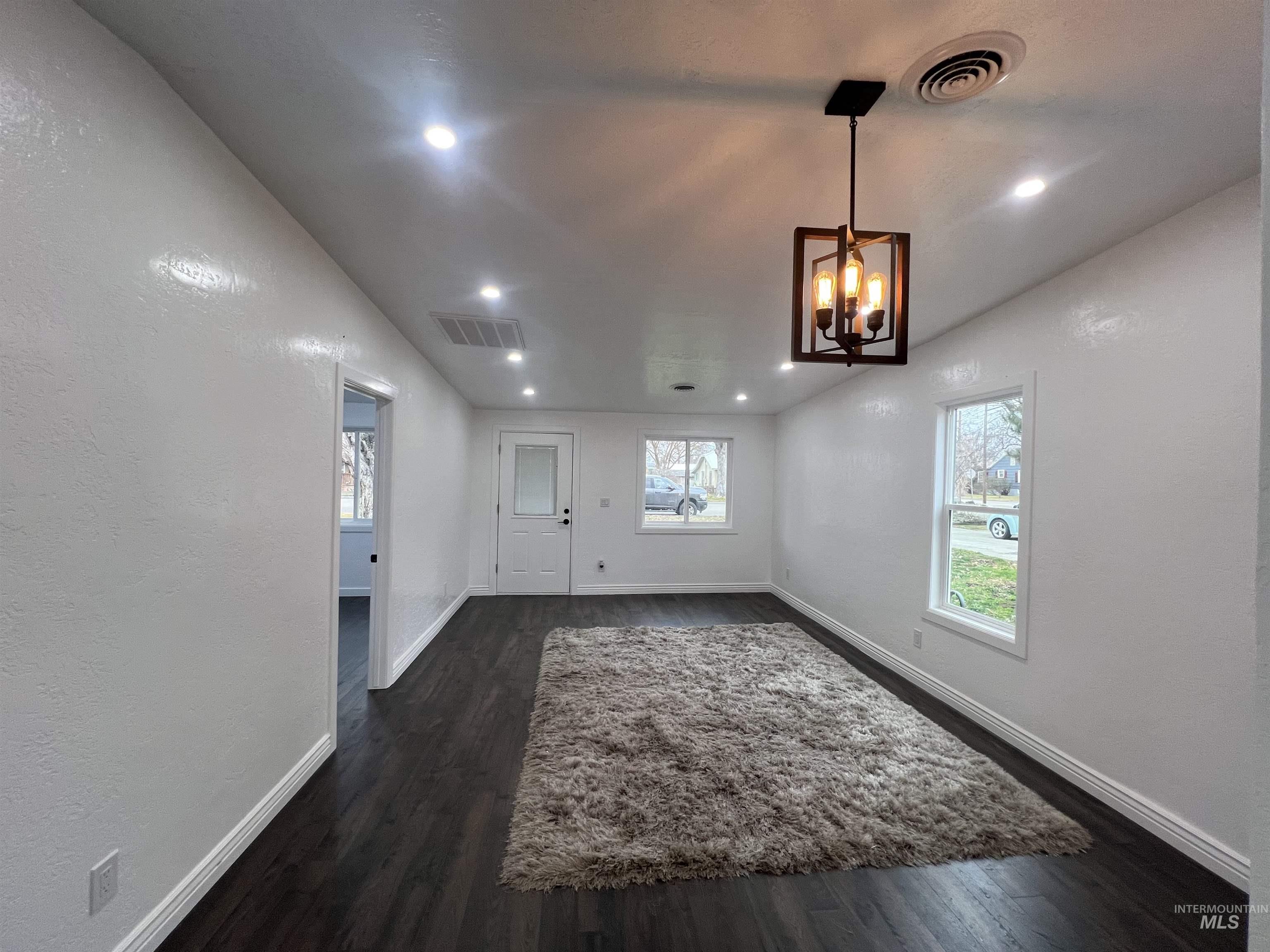 511 North 10th Street Payette, ID 83661 - Photo 6 of 18 Unfurnished dining area featuring a textured wall, dark wood finished floors, and hanging lights