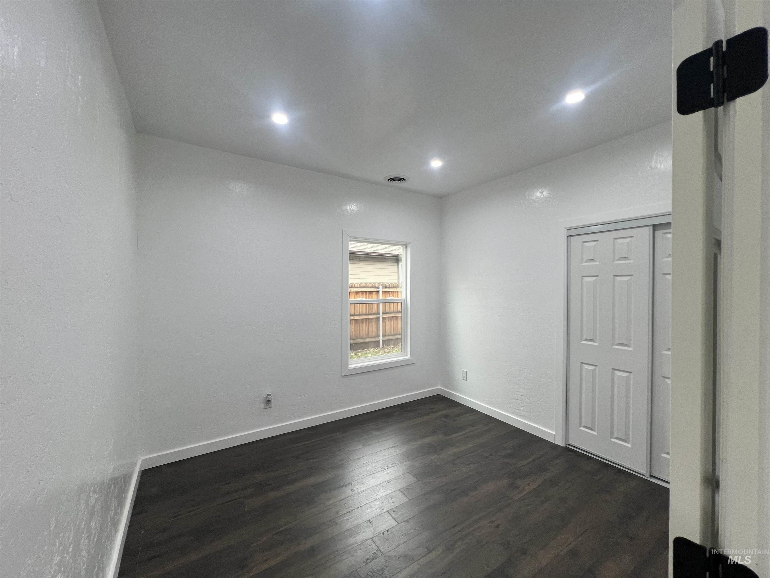 511 North 10th Street Payette, ID 83661 - Photo 9 of 18 Empty room with dark wood finished floors, a textured wall, and recessed lighting