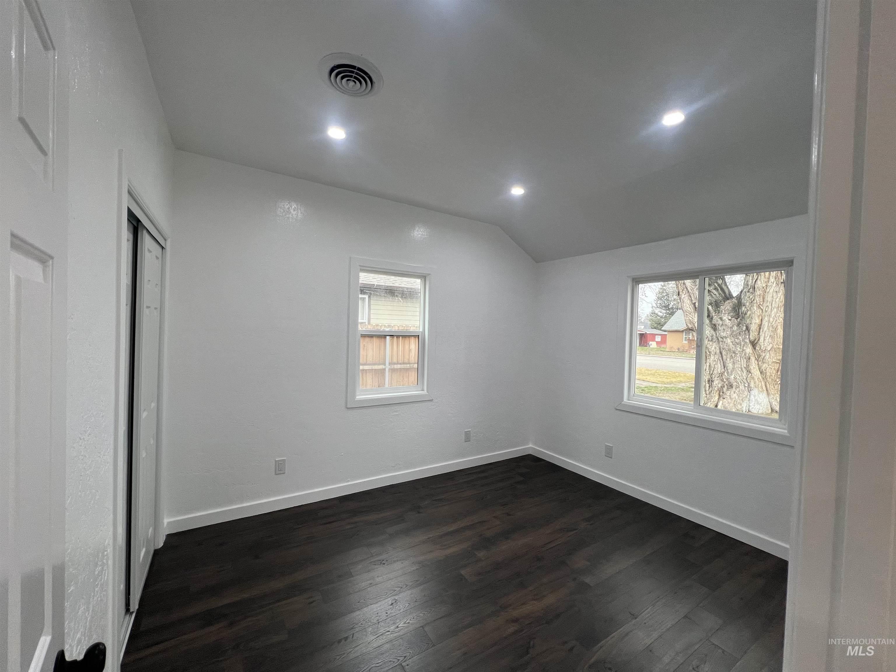 511 North 10th Street Payette, ID 83661 - Photo 10 of 18 Unfurnished bedroom with lofted ceiling, dark wood-type flooring, multiple windows, recessed lighting, and a closet