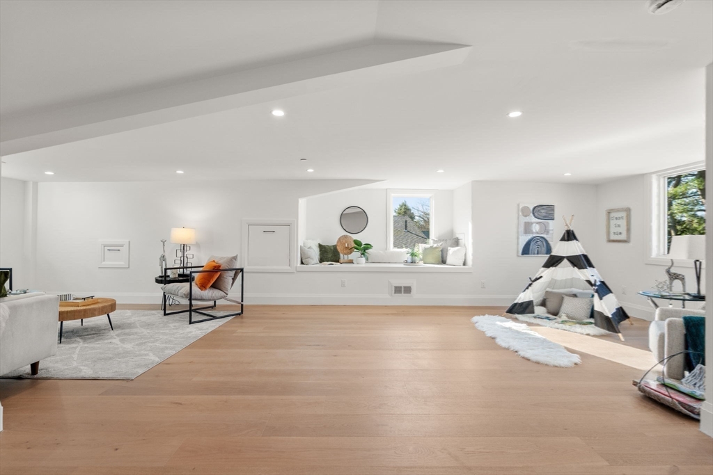 956 Walnut Street, Unit 5 Newton, MA 02459 - Photo 29 of 38 a living room with furniture a mirror and gym equipment