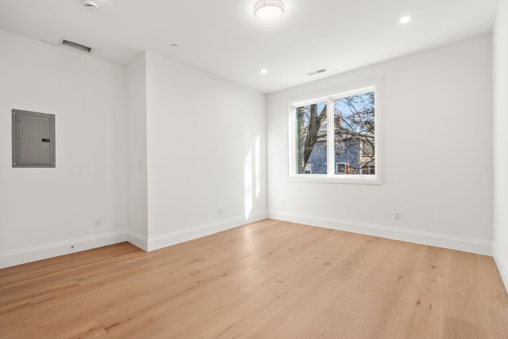 956 Walnut Street, Unit 5 Newton, MA 02459 - Photo 30 of 38 an empty room with wooden floor and windows