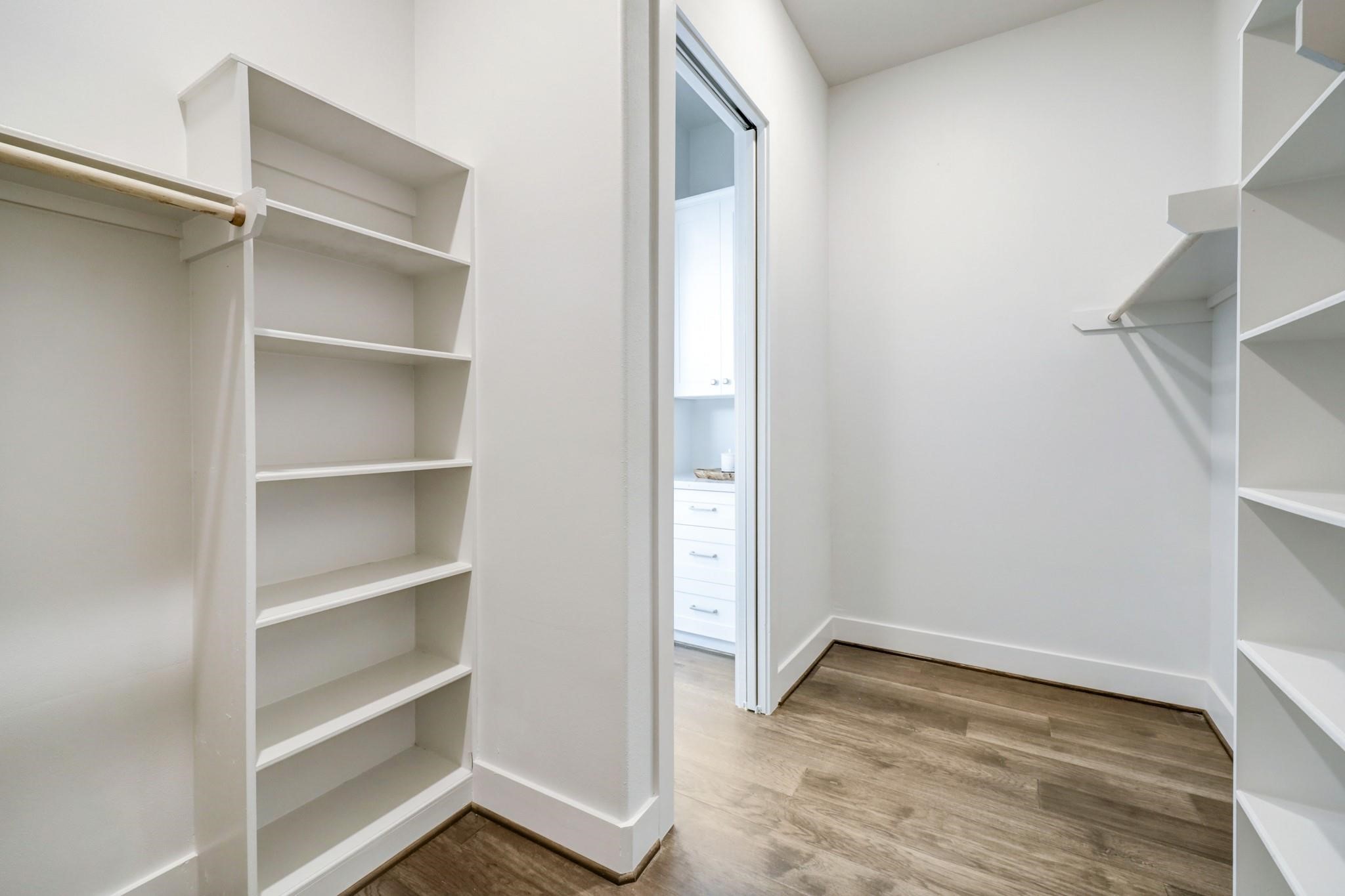 3827 Arlington Street Houston, TX 77018 - Photo 27 of 39 Spacious walk-in closet with built-in shelves and hanging rods, featuring a clean, modern design with light-color walls and wood flooring.