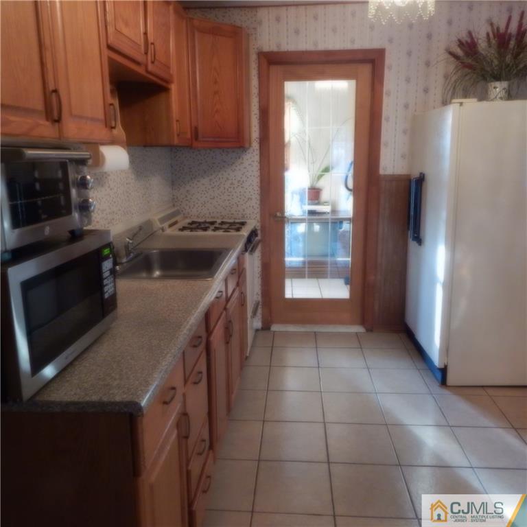 23 Idlewild Road Edison, NJ 08817 - Photo 8 of 19 a kitchen with a stove a refrigerator and a cabinets