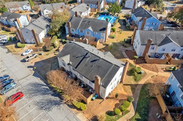 an aerial view of a house with a yard and large tree