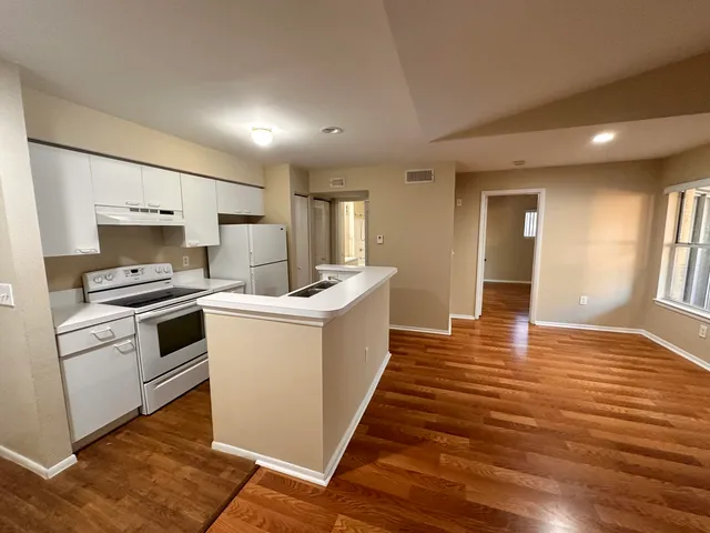 a kitchen with a refrigerator and white cabinets