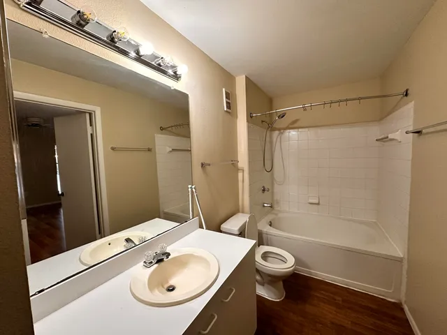 a bathroom with a granite countertop sink toilet a shower and a mirror