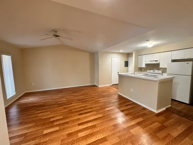 a view of a kitchen with wooden floor and a sink