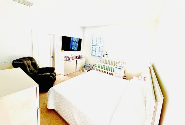 a bedroom with a bed and a flat screen tv