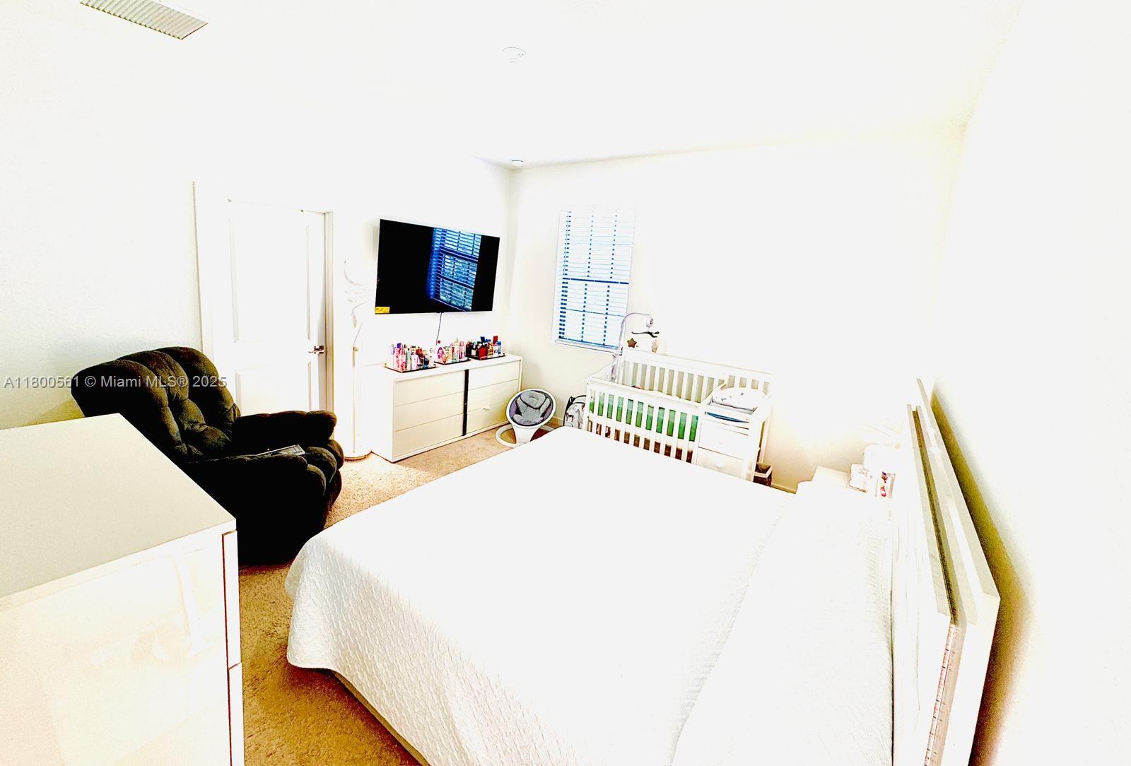 761 Southwest 11th Street, Unit 761 Florida City, FL 33034 - Photo 13 of 18 a bedroom with a bed and a flat screen tv