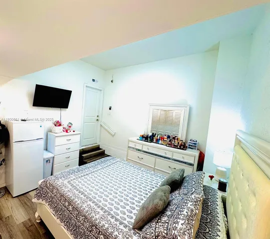 a bedroom with a bed and flat screen tv