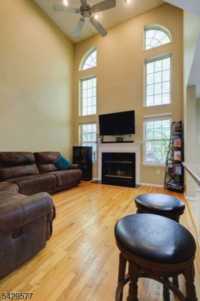 115 Constitution Way Bernards, NJ 07920 - Photo 8 of 31 a living room with furniture a flat screen tv and a fireplace