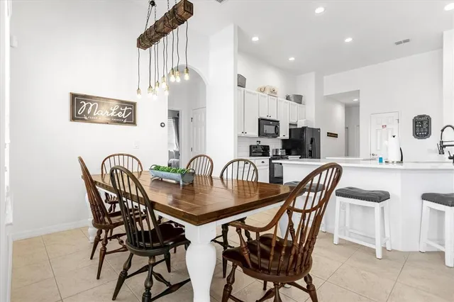 a living room with furniture kitchen view and a chandelier