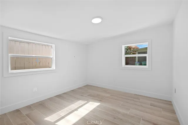 a view of a room that has a window and wooden floor