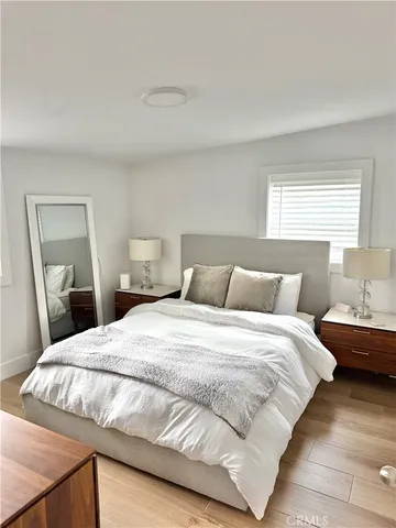 a bedroom with a bed and wooden floor