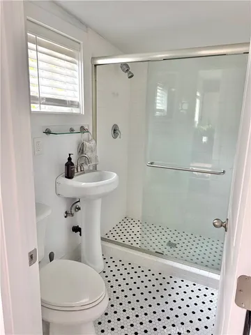 a bathroom with a sink a toilet and shower