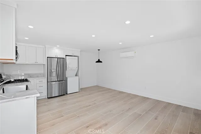 a view of a kitchen with a sink refrigerator and wooden floor