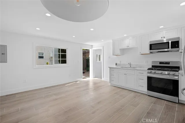 a large kitchen with stainless steel appliances granite countertop a stove and a sink