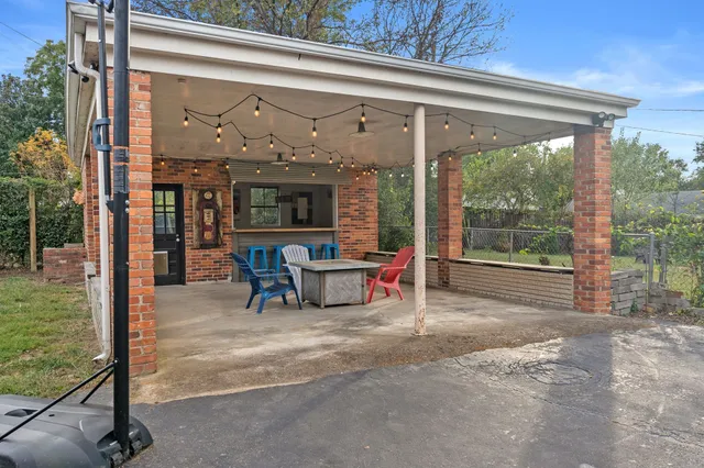 a view of a porch with chairs and couches next to a yard