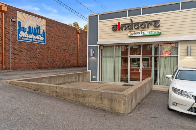 a view of a house with a yard and parking