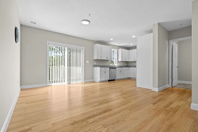 a view of a kitchen with wooden floor and a window