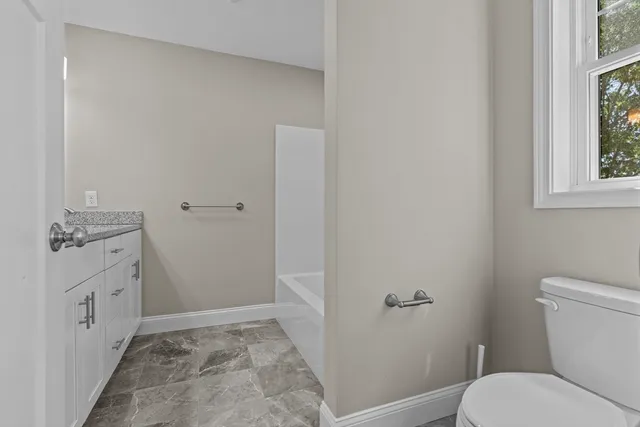 a bathroom with a sink toilet and window