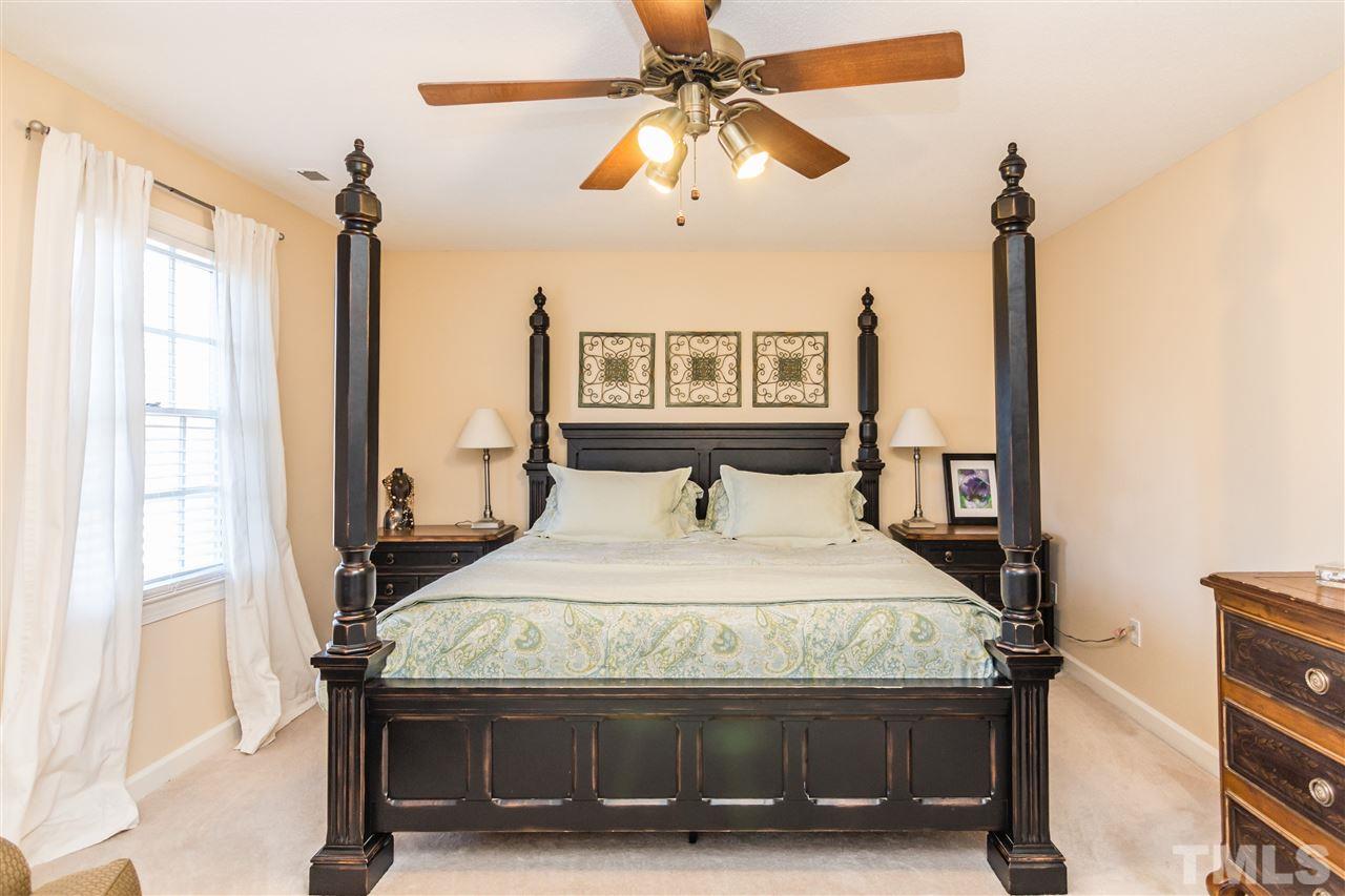 18 Striding Ridge Court Durham, NC 27713 - Photo 15 of 22 a bedroom with a bed and a chandelier