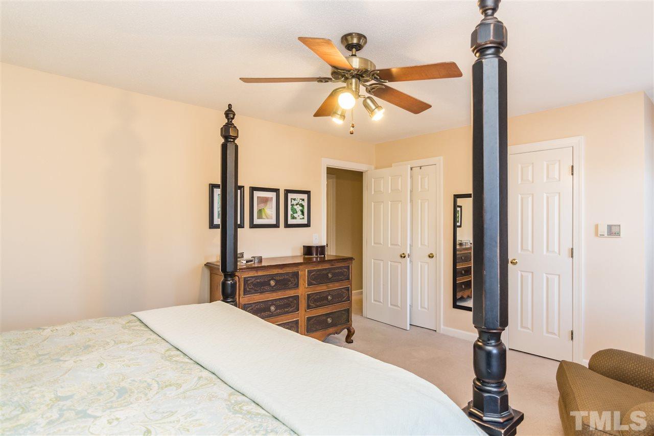18 Striding Ridge Court Durham, NC 27713 - Photo 16 of 22 a bedroom with a bed and a chandelier