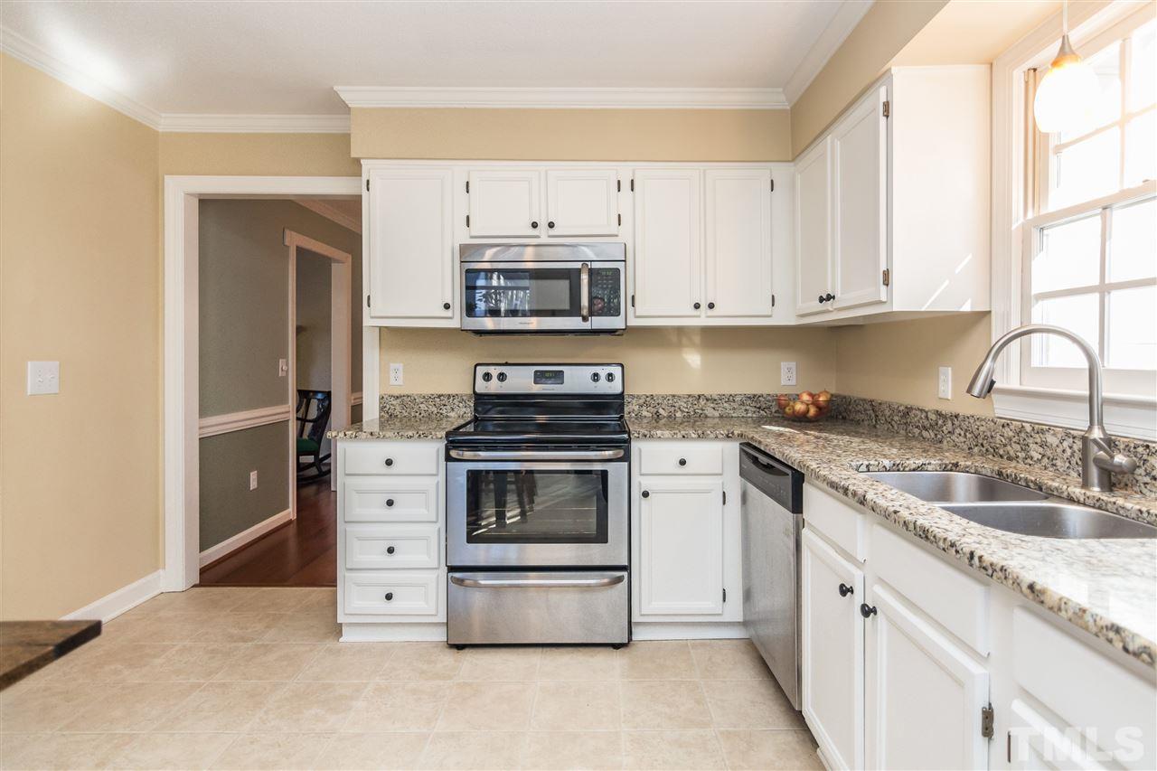 18 Striding Ridge Court Durham, NC 27713 - Photo 10 of 22 a kitchen with granite countertop a stove sink and cabinets