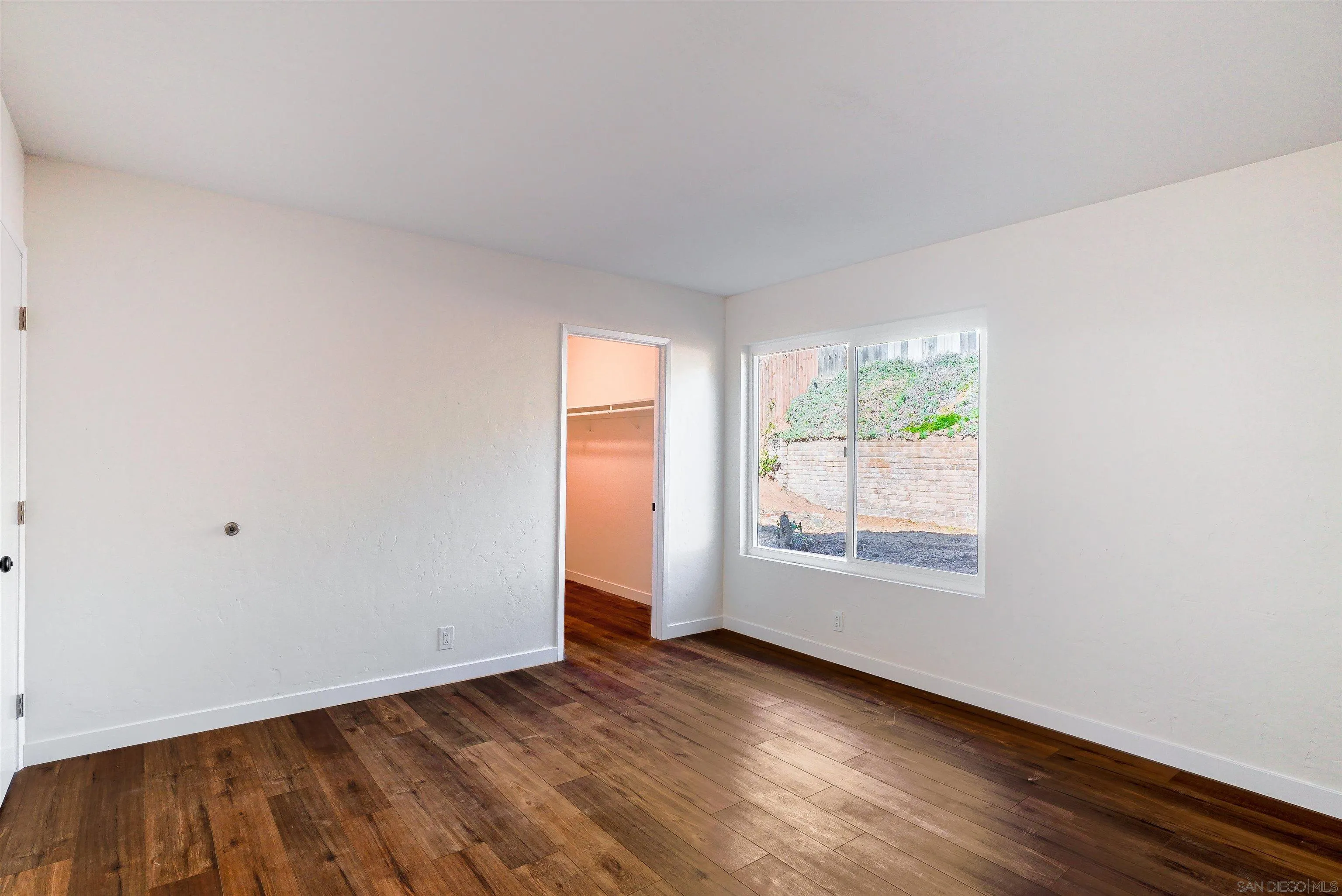 14558 Silla Street Poway, CA 92064 - Photo 14 of 20 an empty room with wooden floor and windows