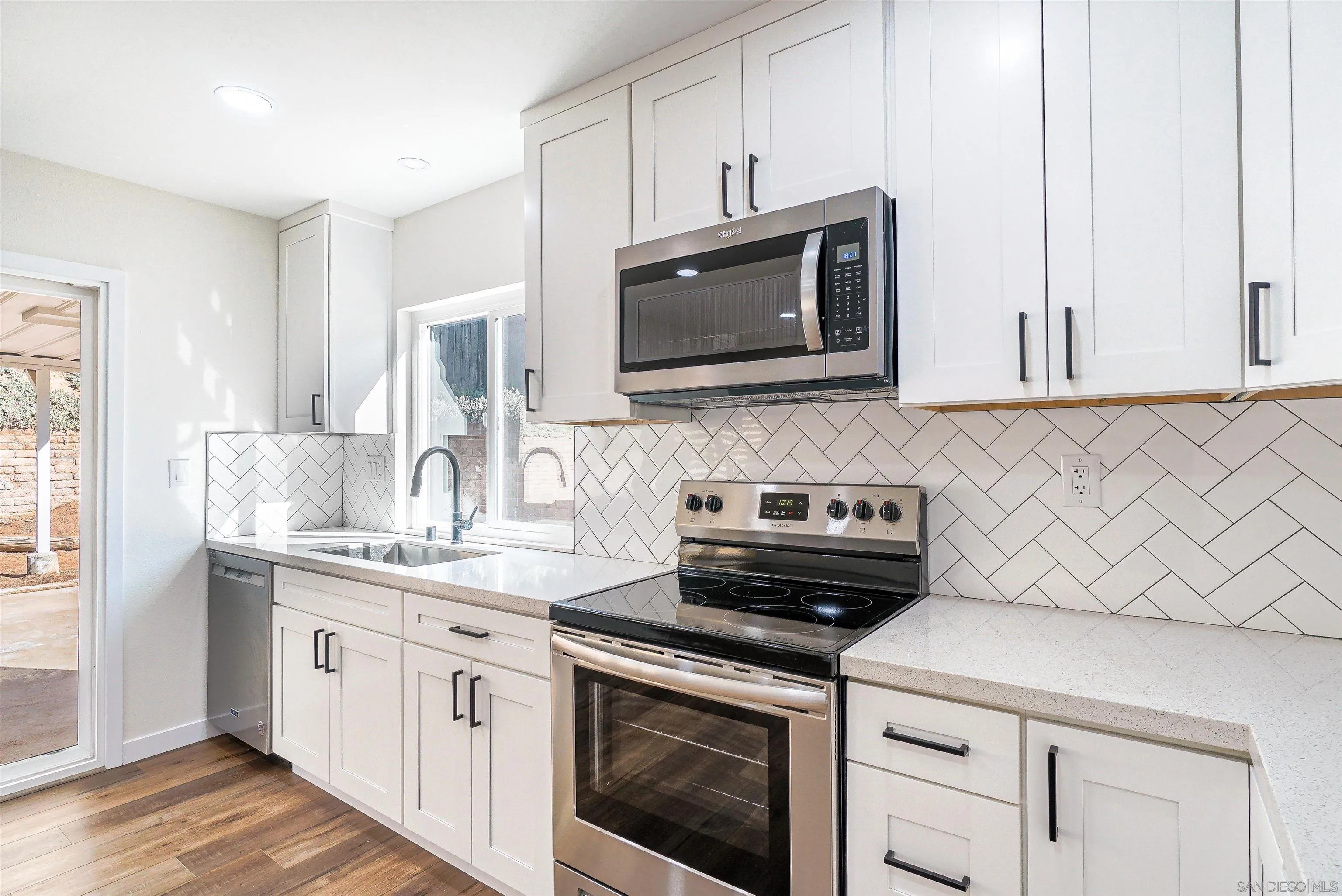 14558 Silla Street Poway, CA 92064 - Photo 5 of 20 a kitchen with stainless steel appliances granite countertop white cabinets a microwave a sink and a counter