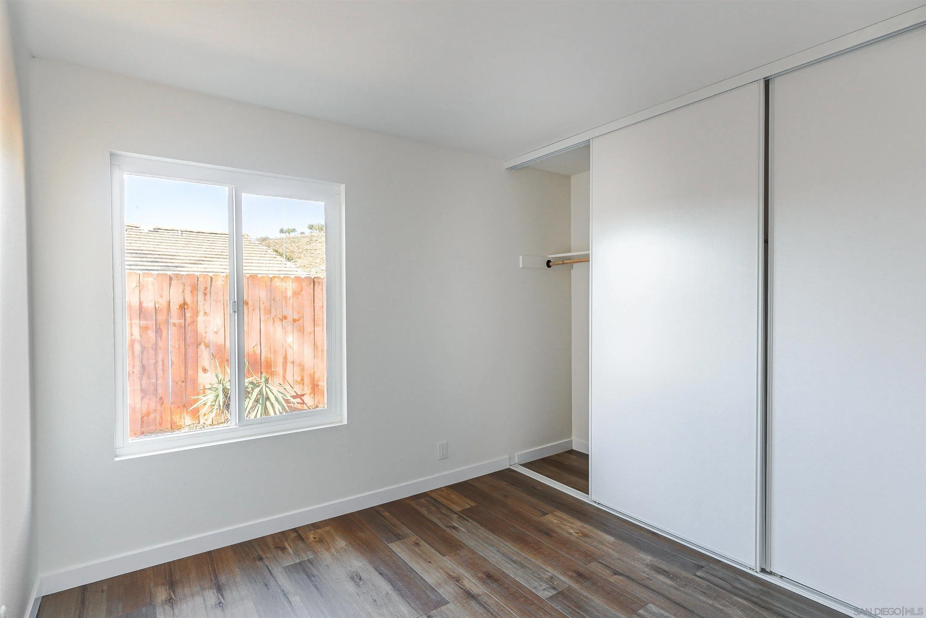 14558 Silla Street Poway, CA 92064 - Photo 9 of 20 a view of an empty room with wooden floor and a window