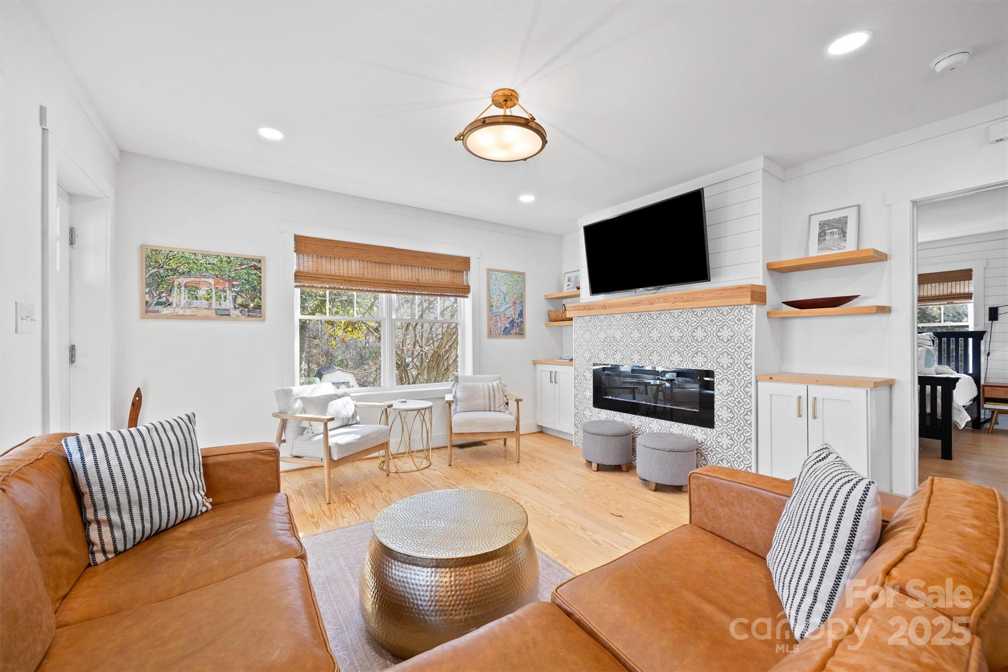 408 Morgan Street Fort Mill, SC 29715 - Photo 3 of 29 a living room with furniture a flat screen tv and a fireplace