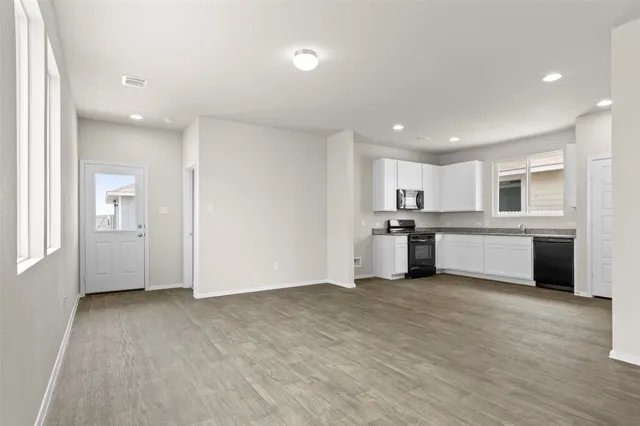 a view of a kitchen with a sink and dishwasher a refrigerator with wooden floor