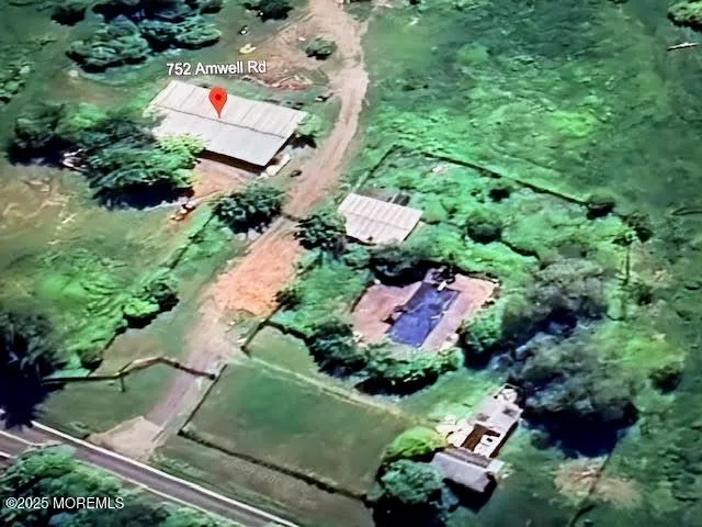 a view of a wooden house with a big yard and large trees