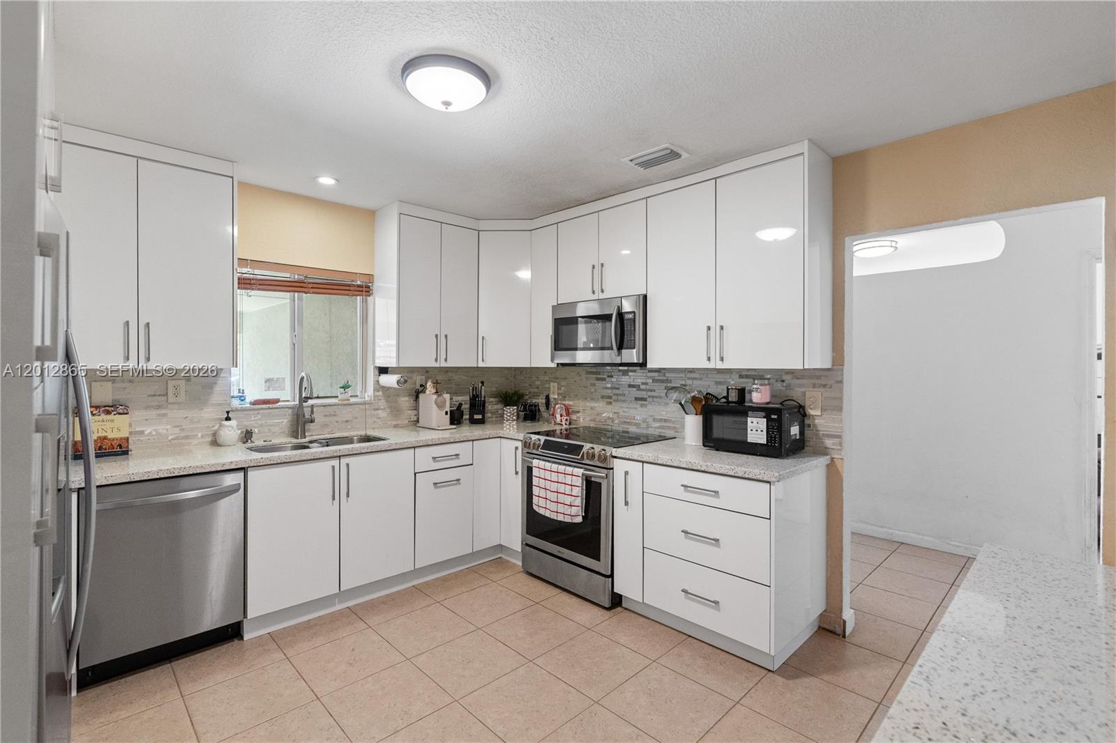 5300 Northwest 30th Place Miami, FL 33142 - Photo 9 of 35 a kitchen with white cabinets appliances and a sink
