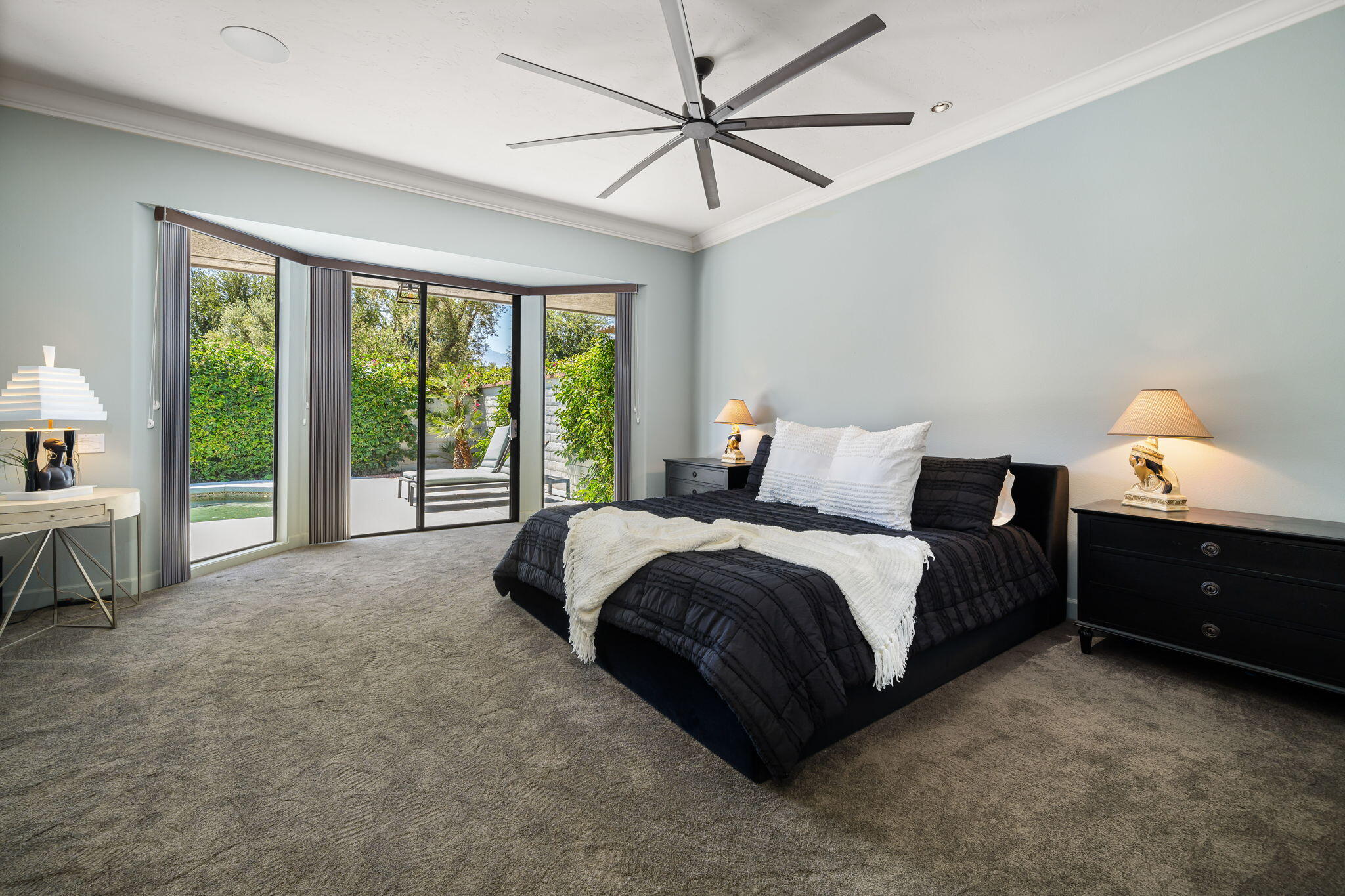 88 Princeton Drive Rancho Mirage, CA 92270 - Photo 16 of 37 a spacious bedroom with a bed and a chandelier