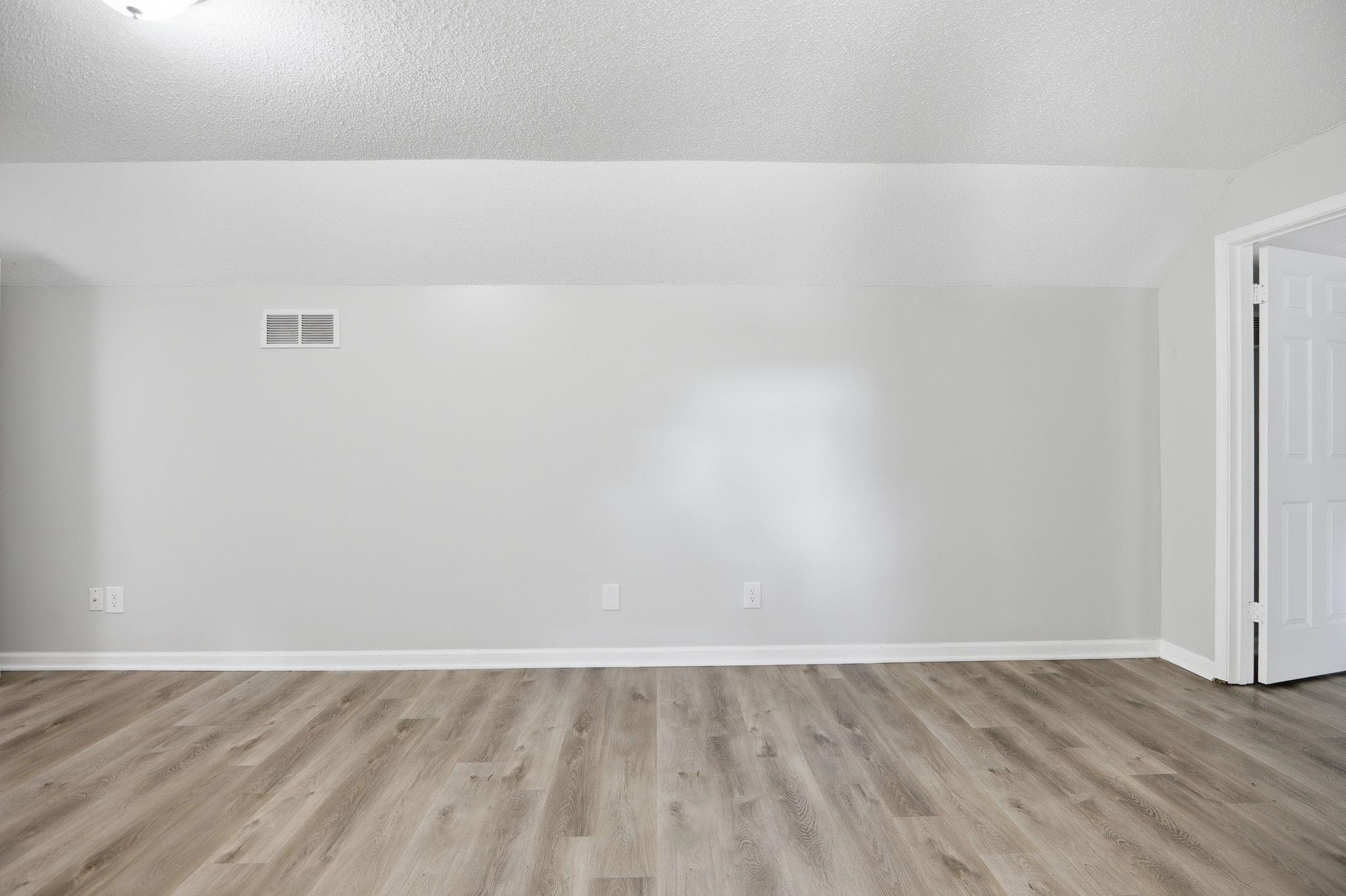 3113 Raleigh Ridge Cove Memphis, TN 38128 - Photo 28 of 38 Room with wood-finish flooring, light grey painted walls, white baseboards, and a white interior door