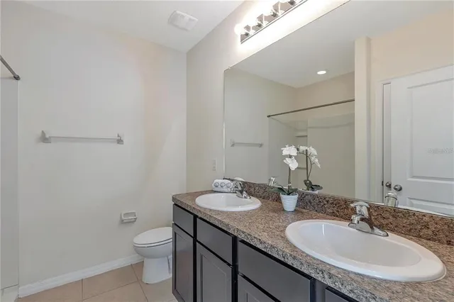 a bathroom with a granite countertop sink a toilet and a mirror