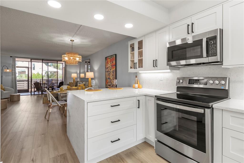 609 Bayport Way, Unit 609 Longboat Key, FL 34228 - Photo 11 of 77 a kitchen with a sink stove and microwave
