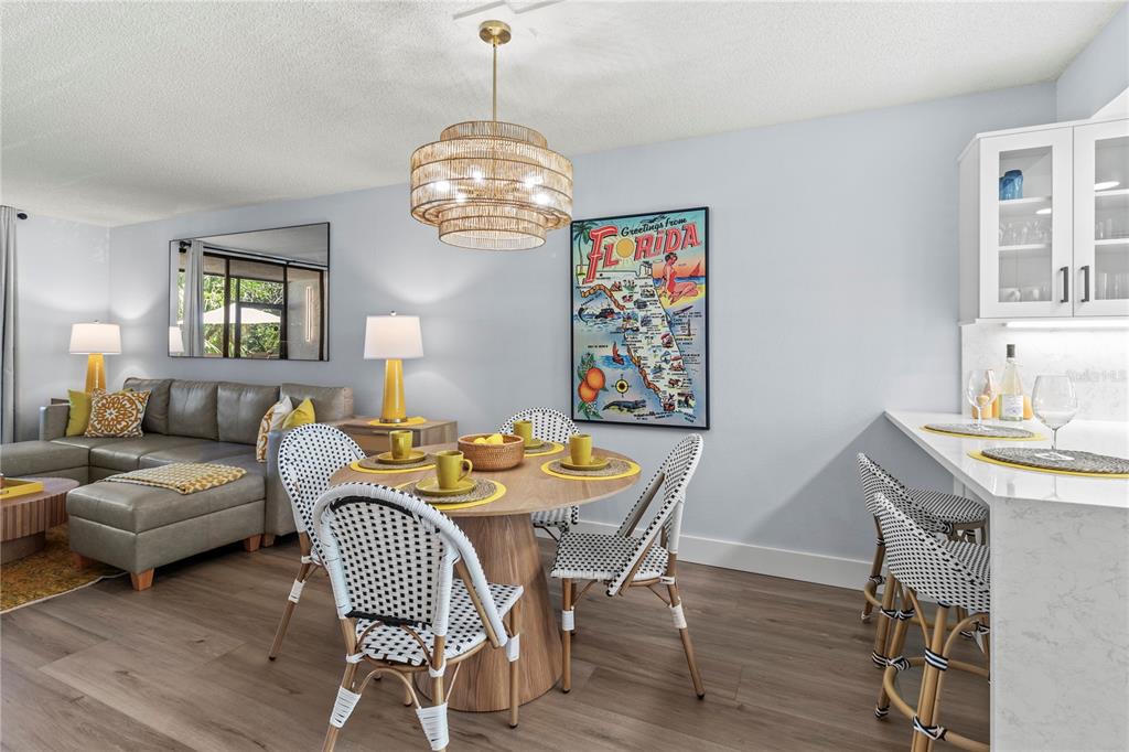 609 Bayport Way, Unit 609 Longboat Key, FL 34228 - Photo 17 of 77 a view of a dining room with furniture a chandelier and wooden floor