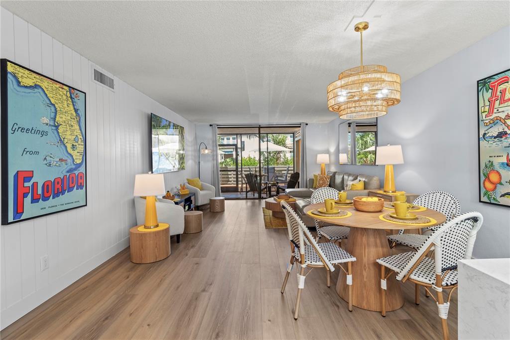 609 Bayport Way, Unit 609 Longboat Key, FL 34228 - Photo 20 of 77 a view of a dining room with furniture wooden floor and chandelier