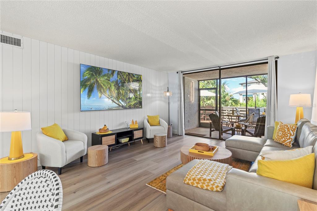 609 Bayport Way, Unit 609 Longboat Key, FL 34228 - Photo 22 of 77 a living room with furniture and a large window with garden view