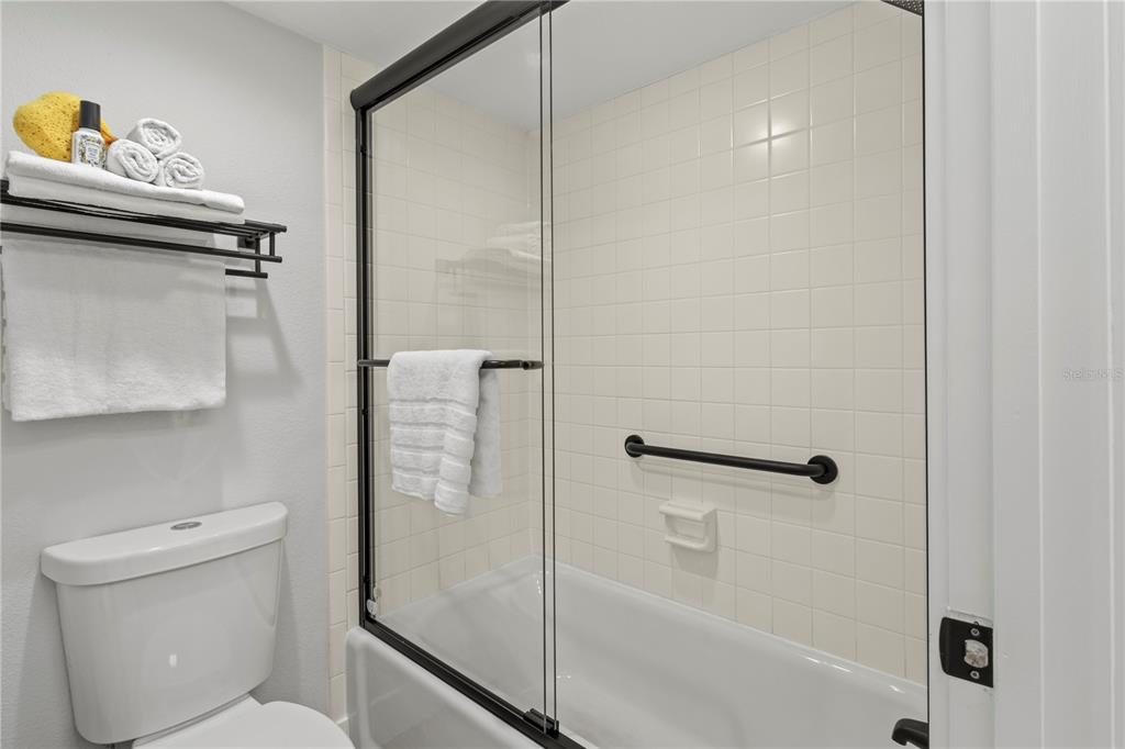 609 Bayport Way, Unit 609 Longboat Key, FL 34228 - Photo 31 of 77 a bathroom with a granite countertop bathtub shower sink vanity and toilet