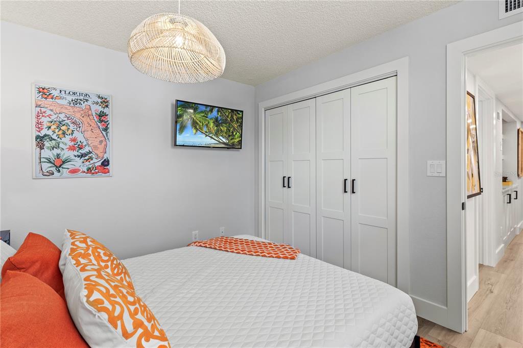 609 Bayport Way, Unit 609 Longboat Key, FL 34228 - Photo 36 of 77 a bedroom with a bed and a chandelier